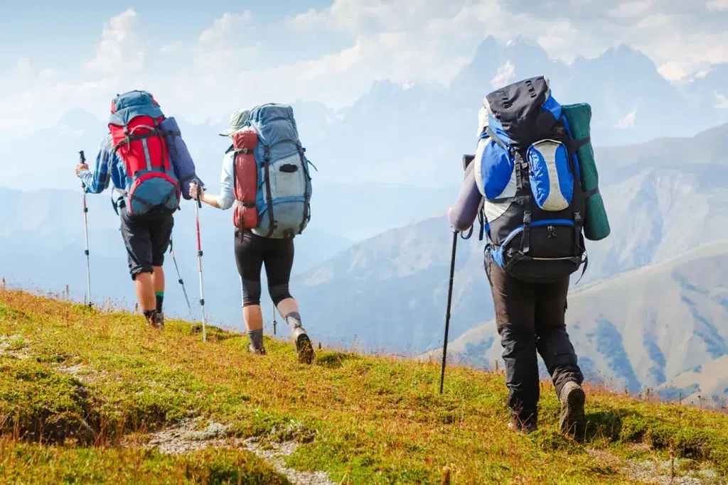 three people backpacking on a mountain