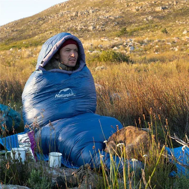 Man sitting in a Naturehike mummy sleeping bag